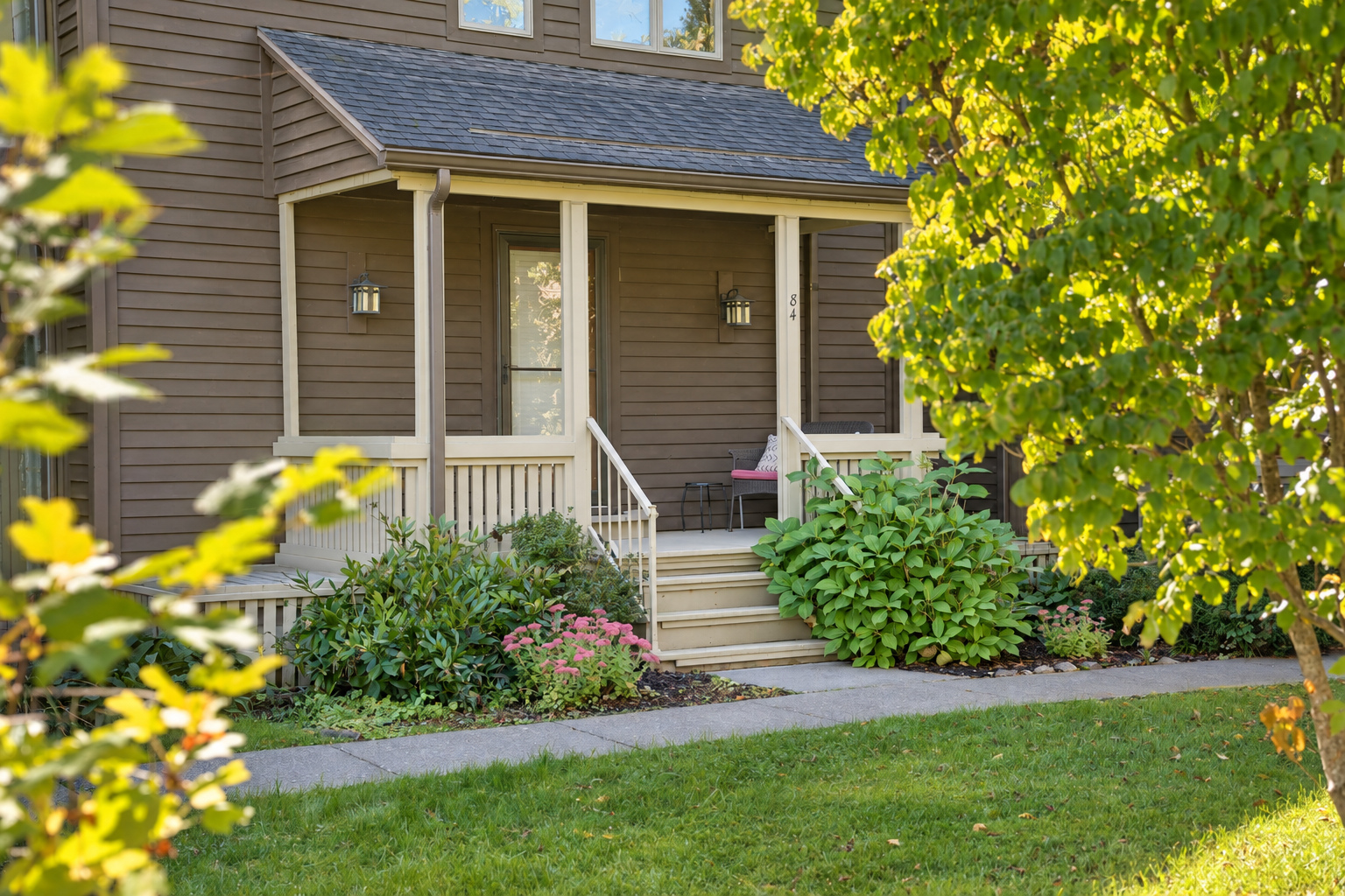 Front porch of 84 Lois Lane framed by trees and landscaping